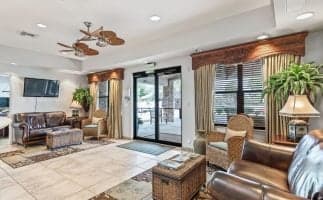 Hotel lobby featuring leather furniture and a ceiling fan, creating a stylish and comfortable atmosphere for guests.