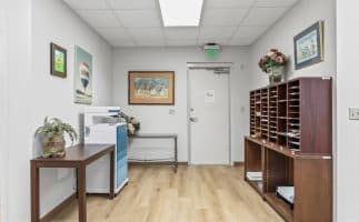 A hallway featuring a desk with a printer positioned beside it, creating a functional workspace.