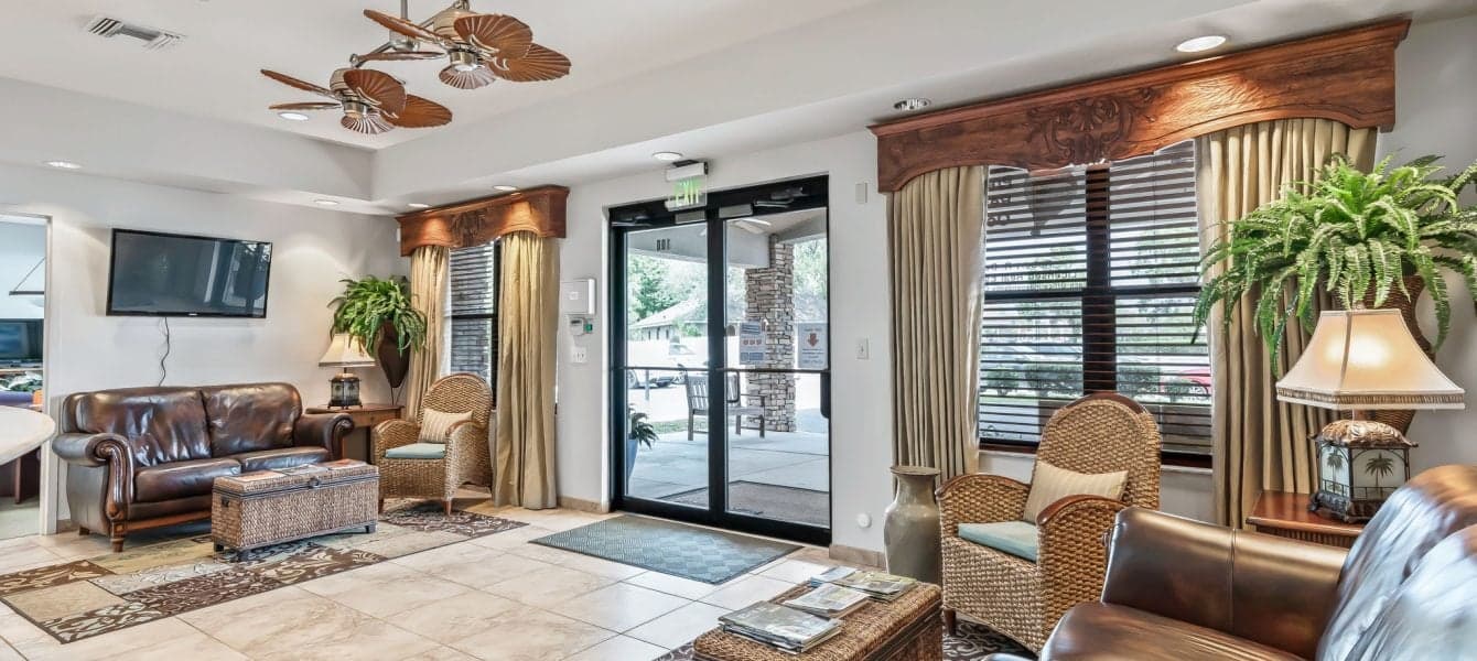 Hotel lobby featuring leather furniture and a ceiling fan, creating a stylish and comfortable atmosphere for guests.